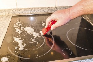 Ceramic hob, induction hob cleaning. Stove with detergent and cleaning cloth.