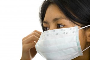 asian woman putting on a face mask